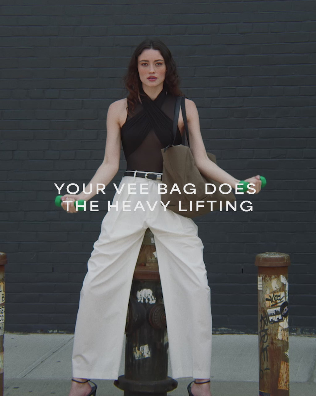 A video featuring a model wearing a sleeveless top and white trousers, carrying an Essence Medium Mink Bag while exercising with weights.