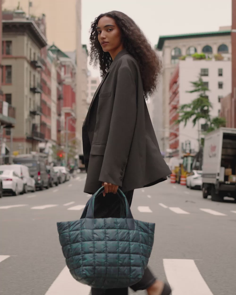 Video of a woman walking across a crosswalk carrying the Porter Tote Bag Medium in Bottle Green.