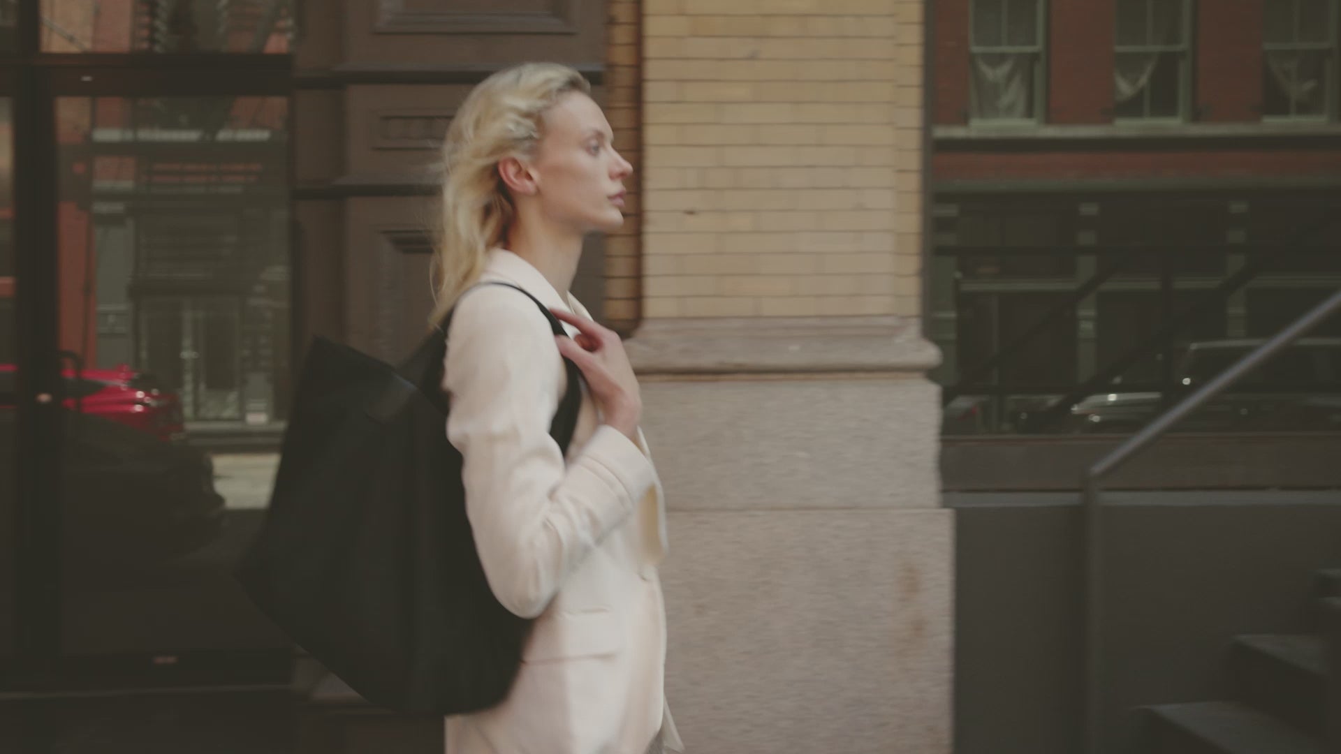 Woman in motion walking through NYC, carrying Vee Collective Porter Essence Mini and Olive bags.