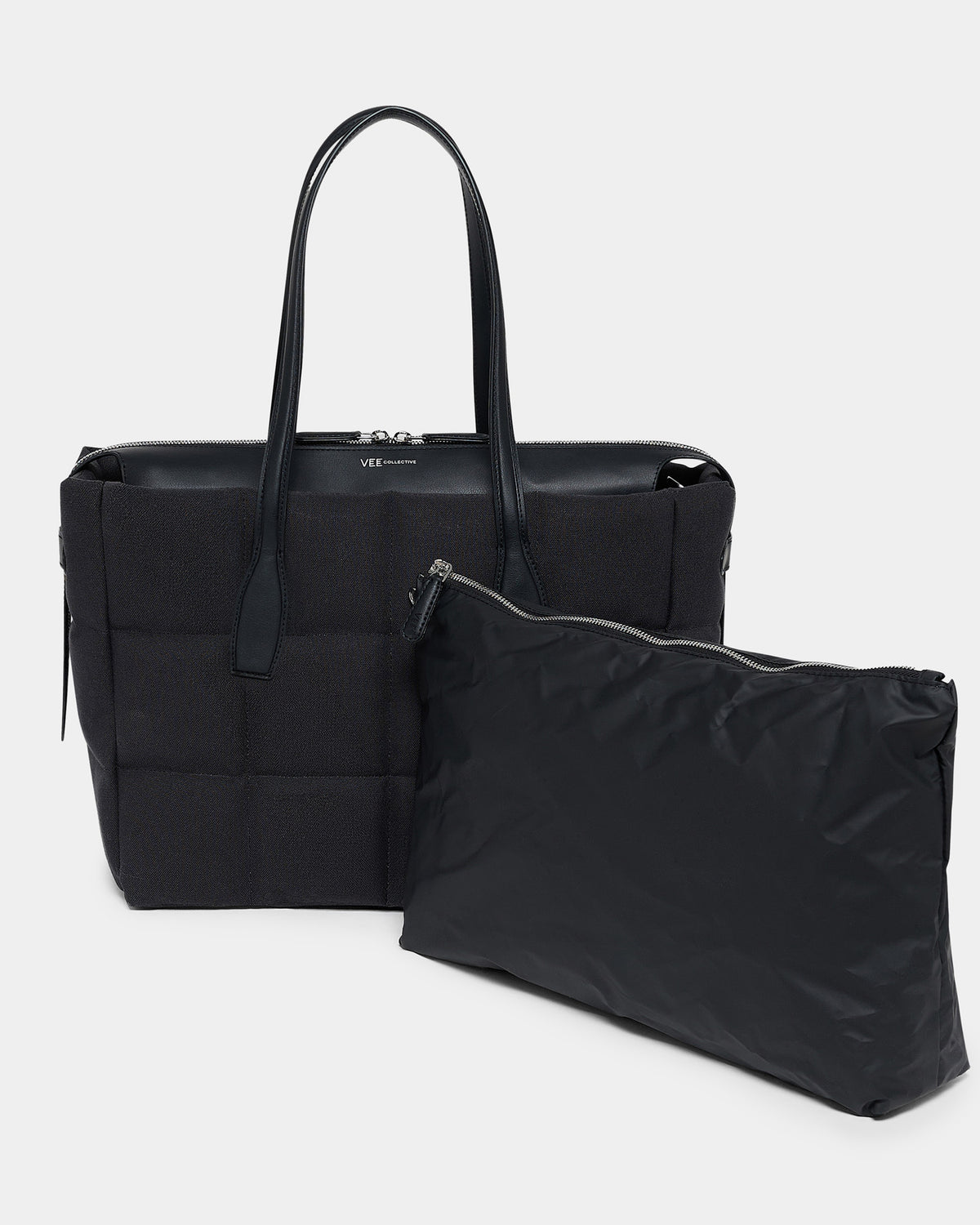 A photo of a Tela Tote featuring matching leather handles and trim, paired with a matching pouch, displayed against a plain white background.