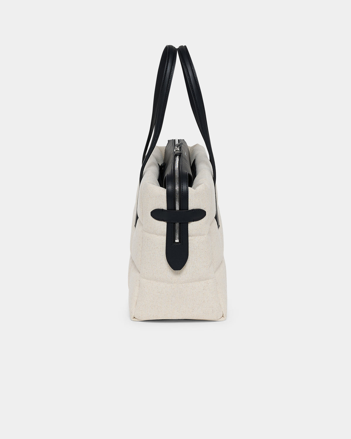 A photo of a Tela Tote Shoulder Bag featuring a silver-tone metal zipper and a black leather cross detail on the front, shown from a rear three-quarter view against a plain white background.