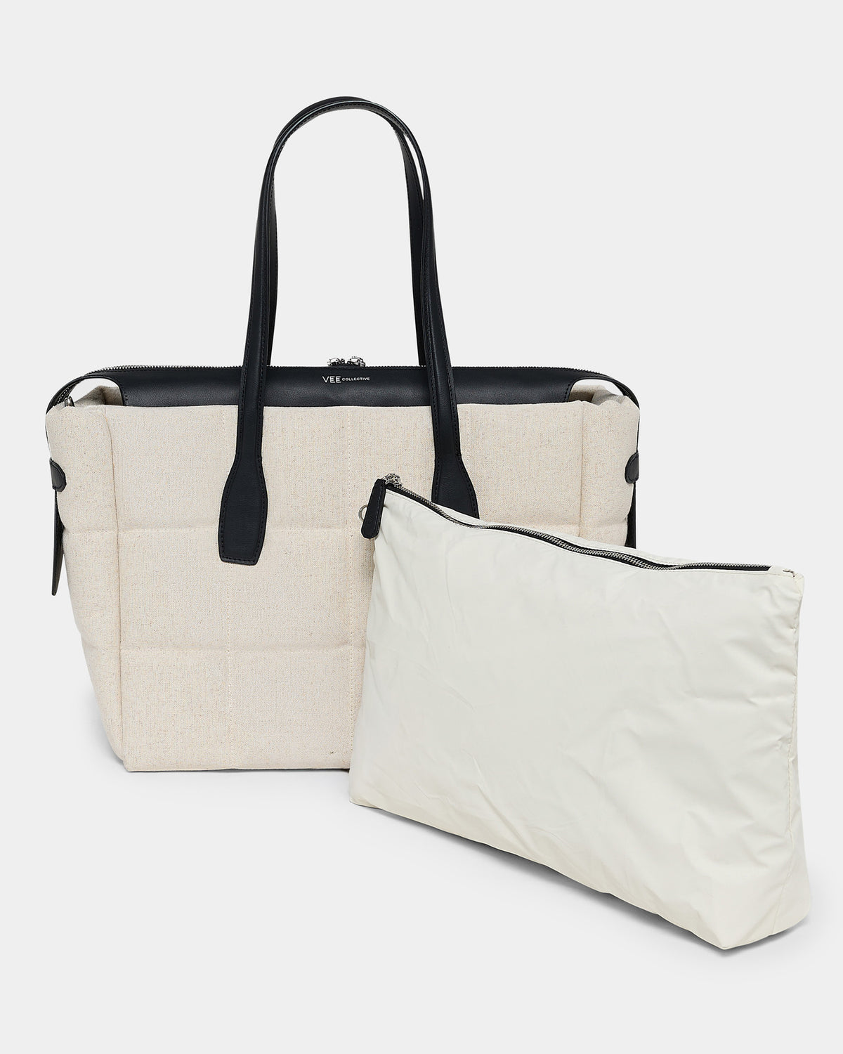 A photo of a Tela Tote featuring matching leather handles and trim, paired with a matching pouch, displayed against a plain white background.