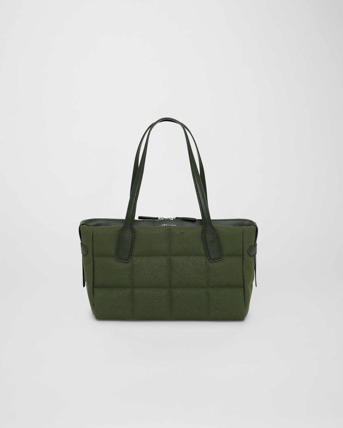 A photo of a Tela Tote featuring black leather handles and trim, displayed against a plain white background. size_picker