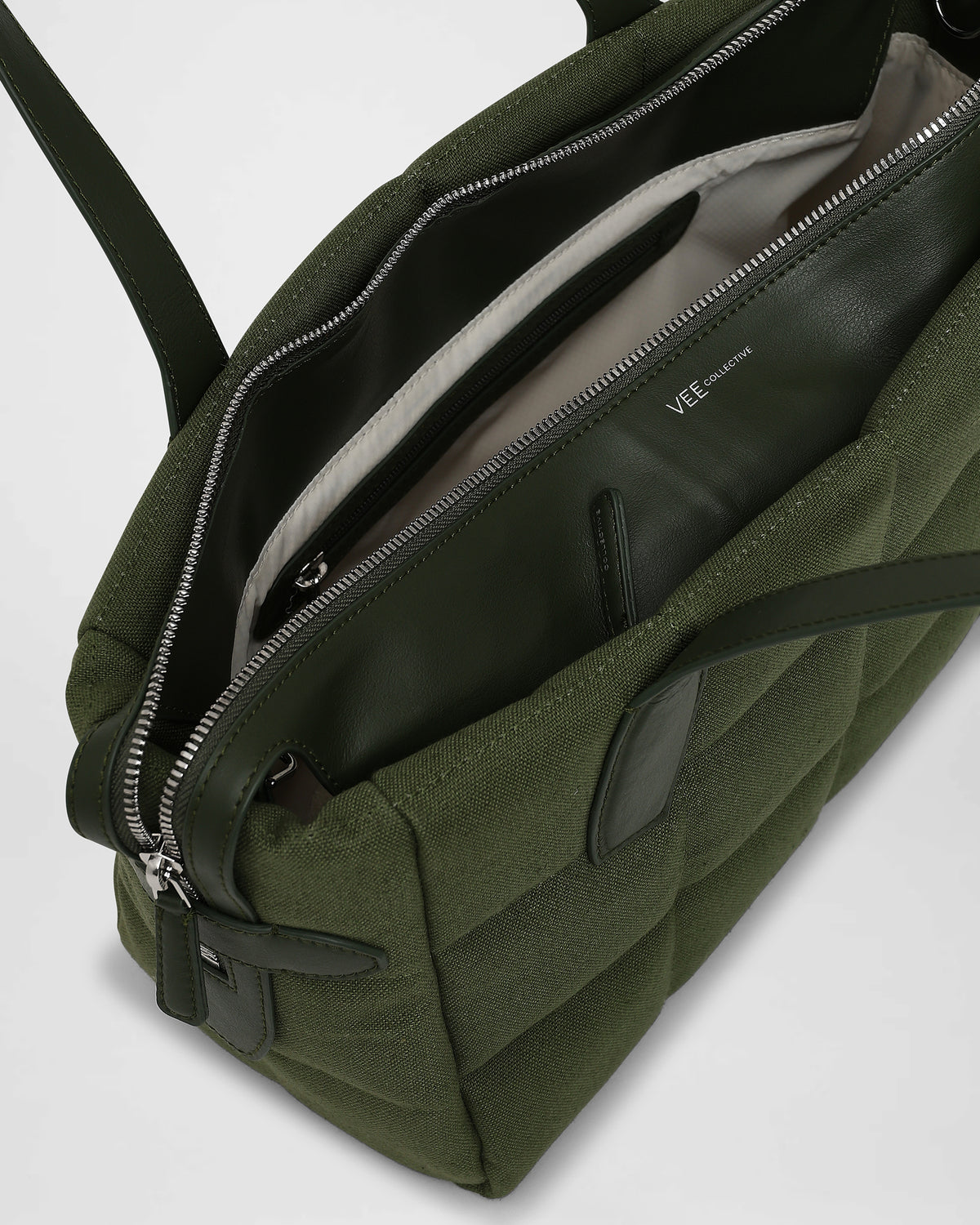 A clean product photo of an open Tela Tote, revealing its light beige interior lining, displayed against a plain white background.
