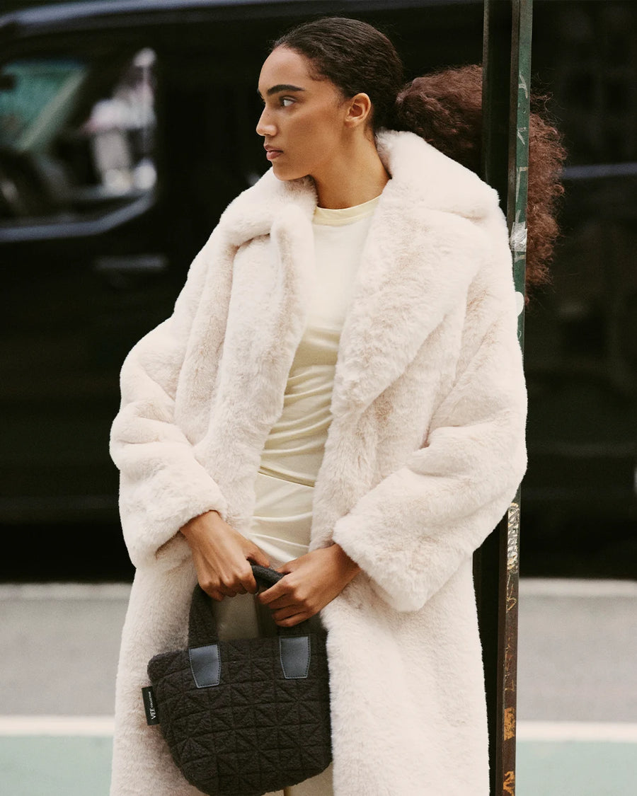 Woman carrying the VEE COLLECTIVE Vee Tote Mini Black Sherpa tote bag.