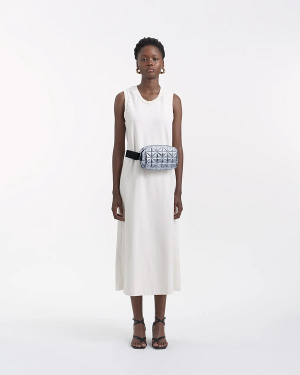 On-body picture of a woman carrying the Vee Belt Bag in Icy Silver by Vee Collective, wearing a minimalistic outfit against a clean studio background.