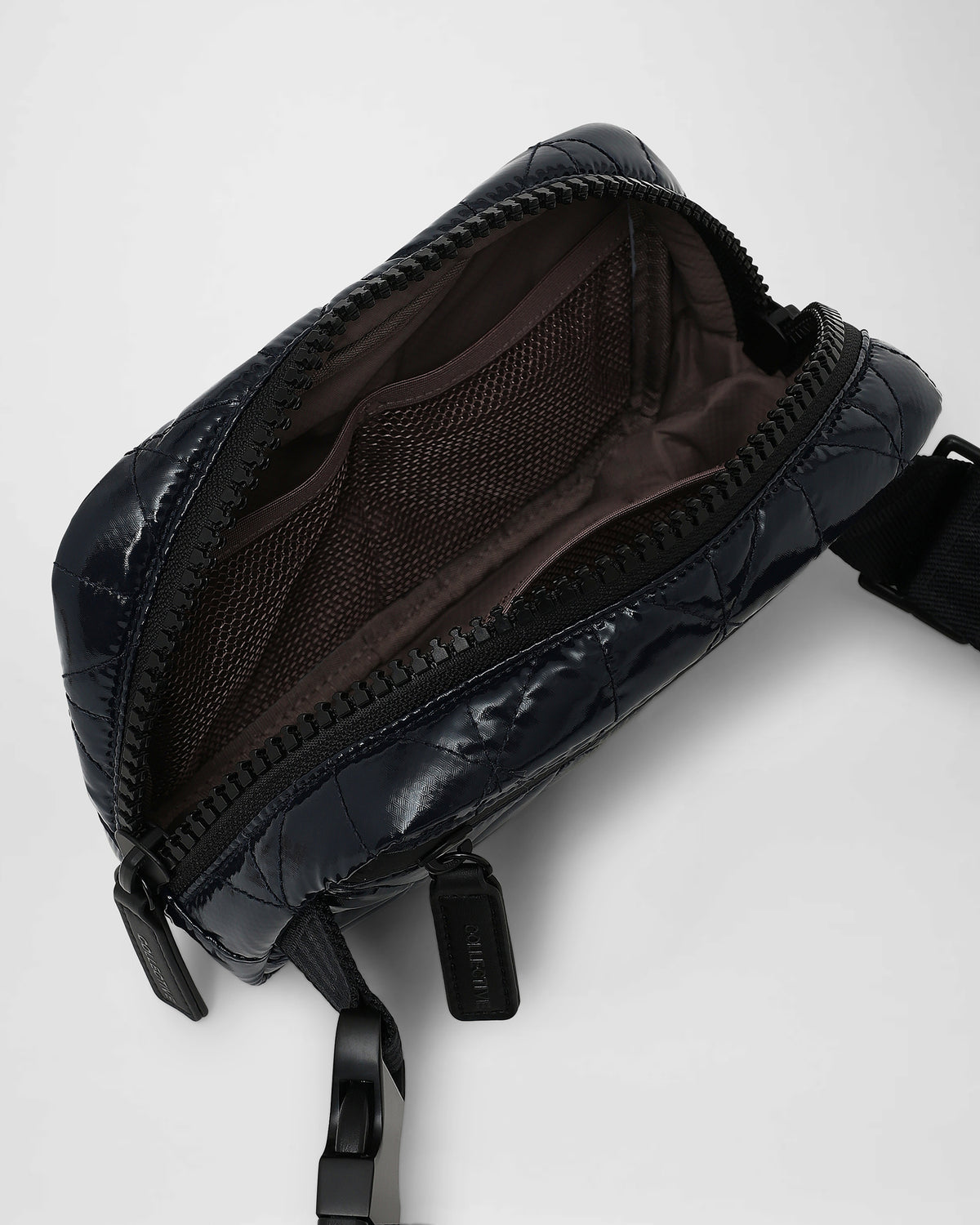A photo of a Vee Belt Bag shown open, featuring a visible interior lining, set against a plain white background.