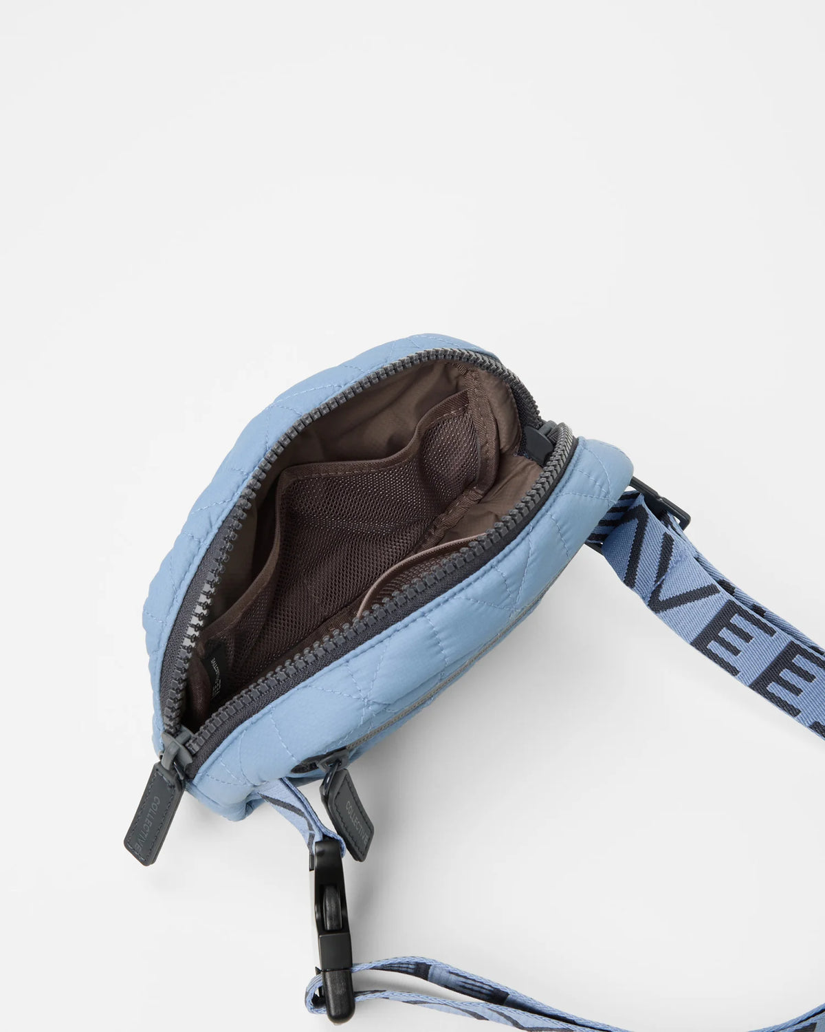 Open Vee Collective Vee Belt Bag in Pigeon Blue, showing the quilted exterior, top zipper, and interior compartments of the tote bag.
