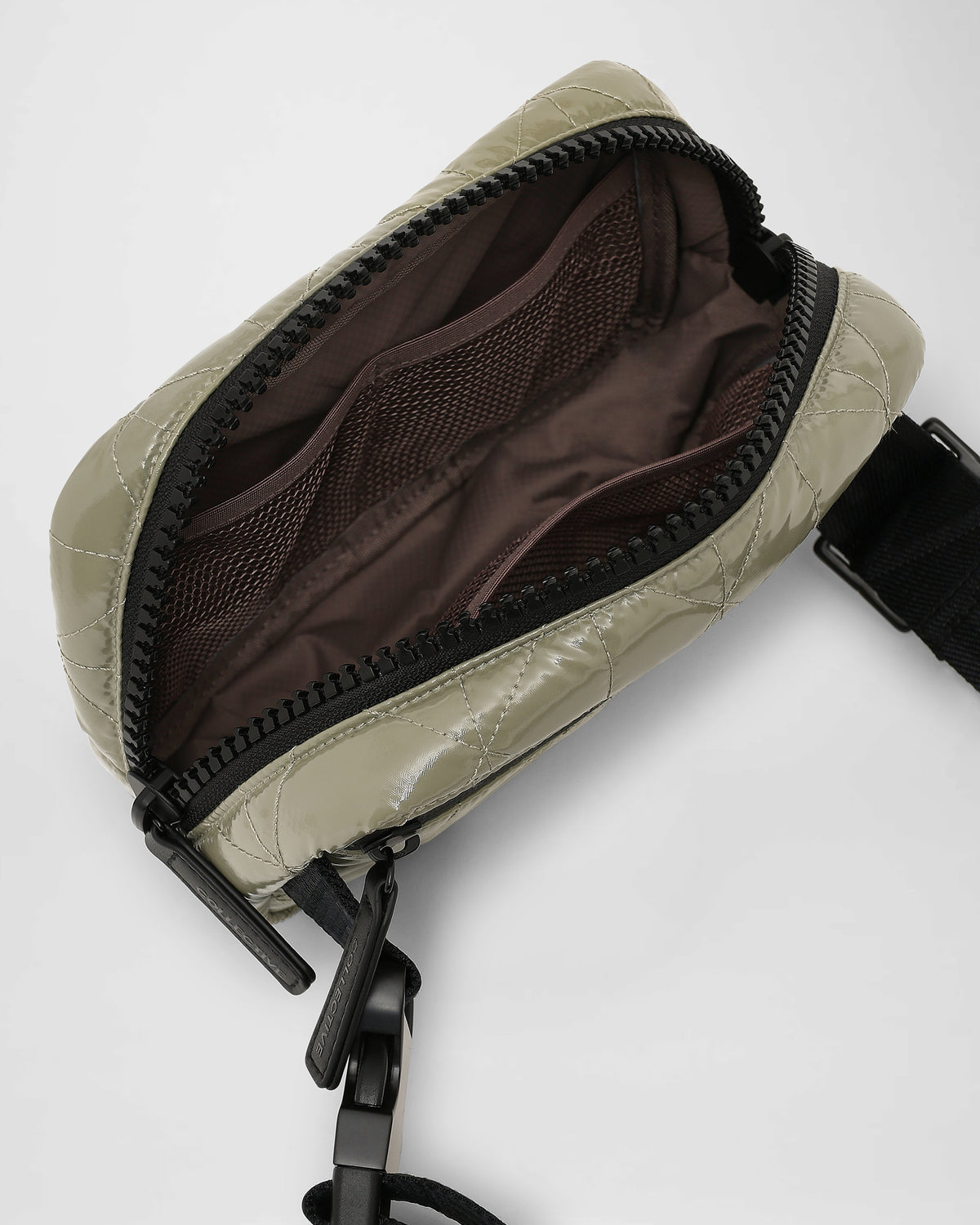 An overhead photo of an open Vee Belt bag, showing a dark interior lining, displayed against a plain white background.