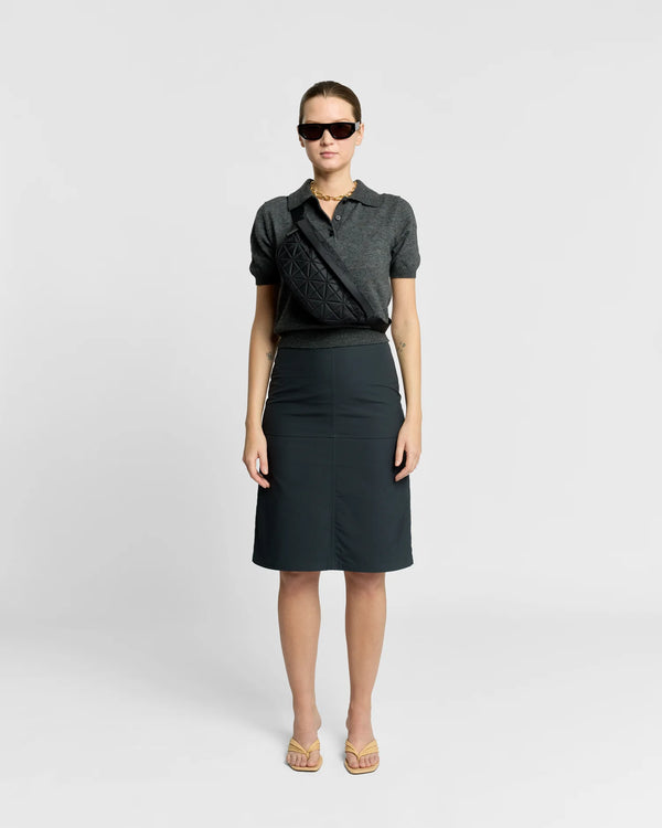 Woman in a minimal, clean outfit carrying the Vee Collective Vee Fanny Pack Bag in Black.