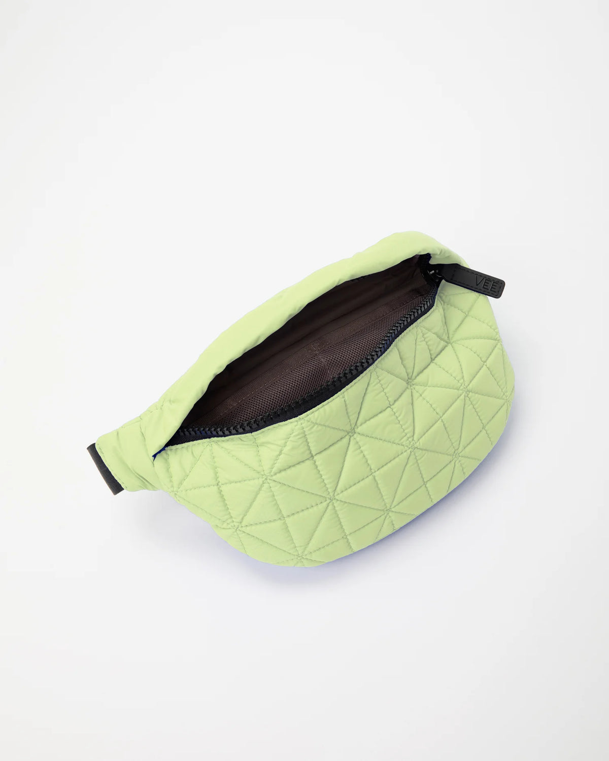 Open Vee Collective Vee Fanny Pack in Limelight, showing the quilted exterior, top zipper, and interior compartments of the tote bag.