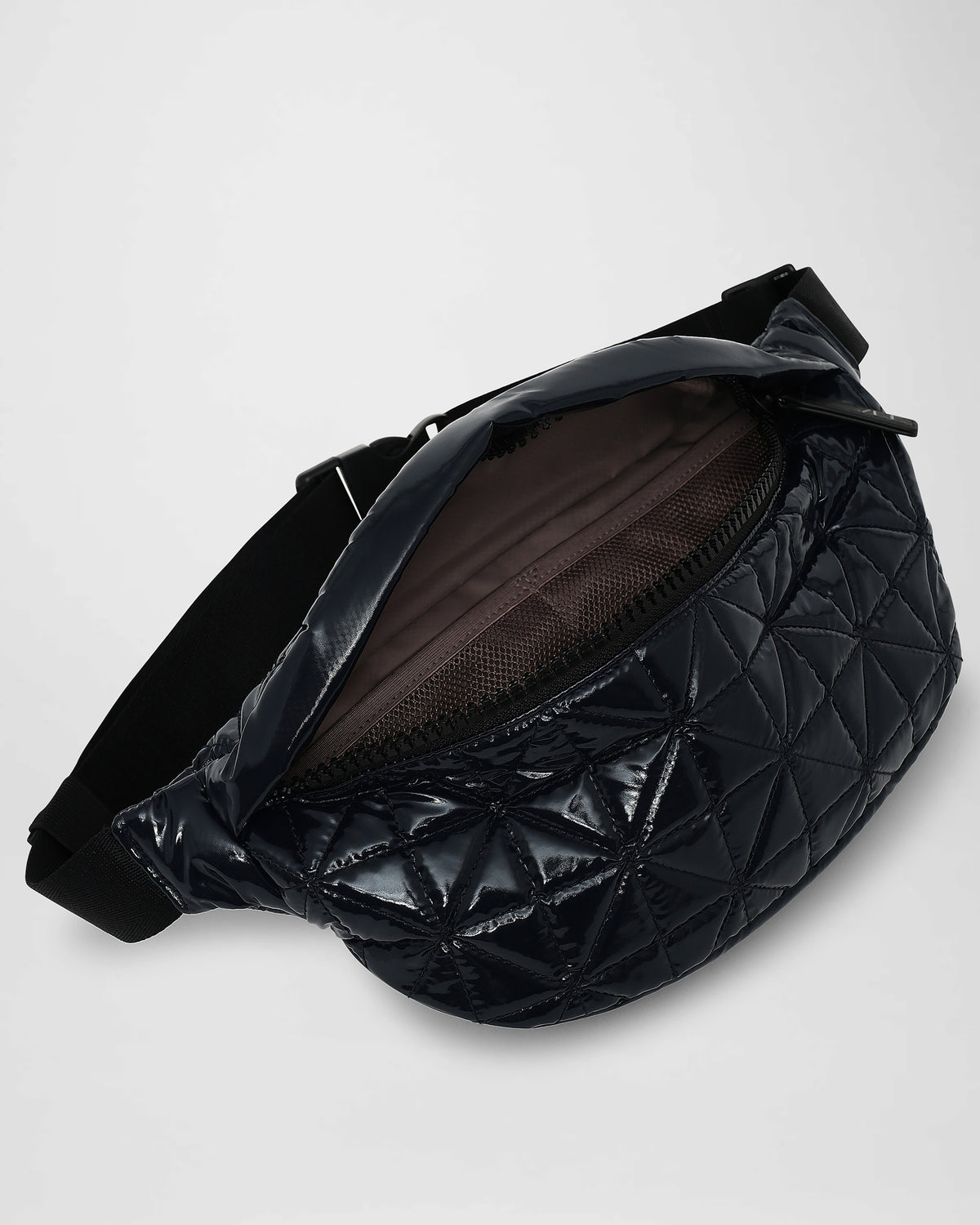 An overhead photo of an open Vee Fanny pack, showing a dark interior lining, displayed against a plain white background.