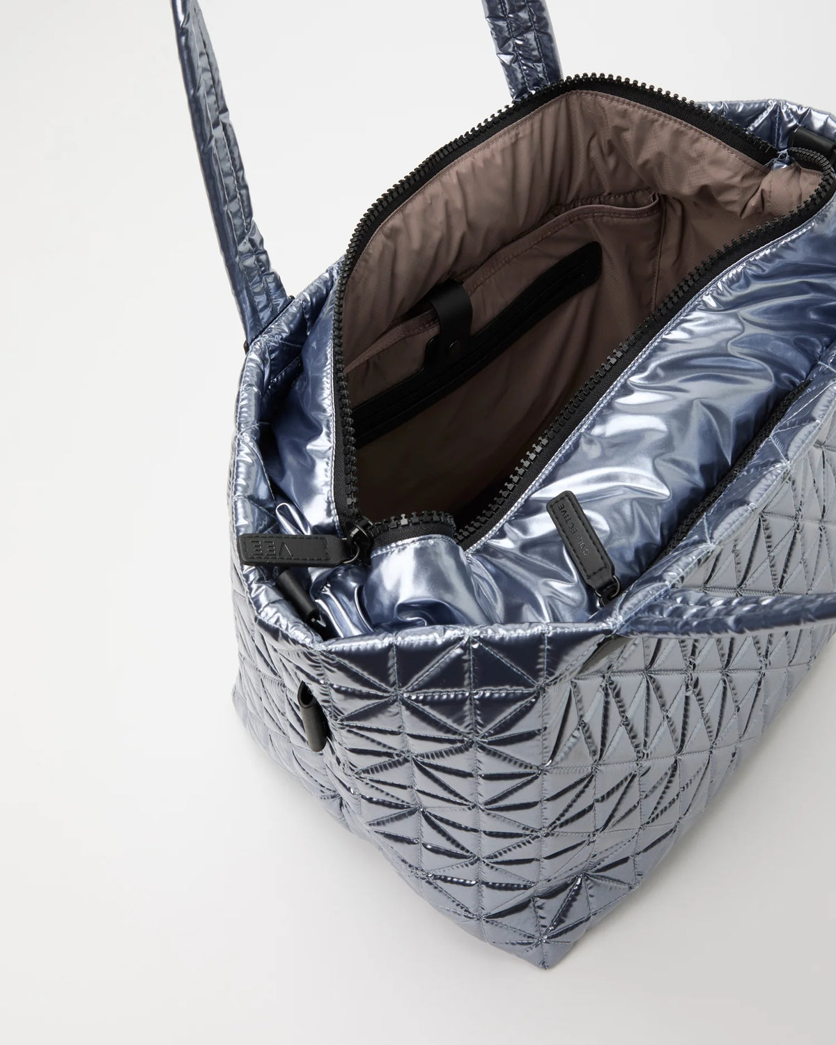 Open Vee Collective Vee Tote Medium in Icy Silver, showing the quilted exterior, top zipper, and interior compartments of the tote bag.