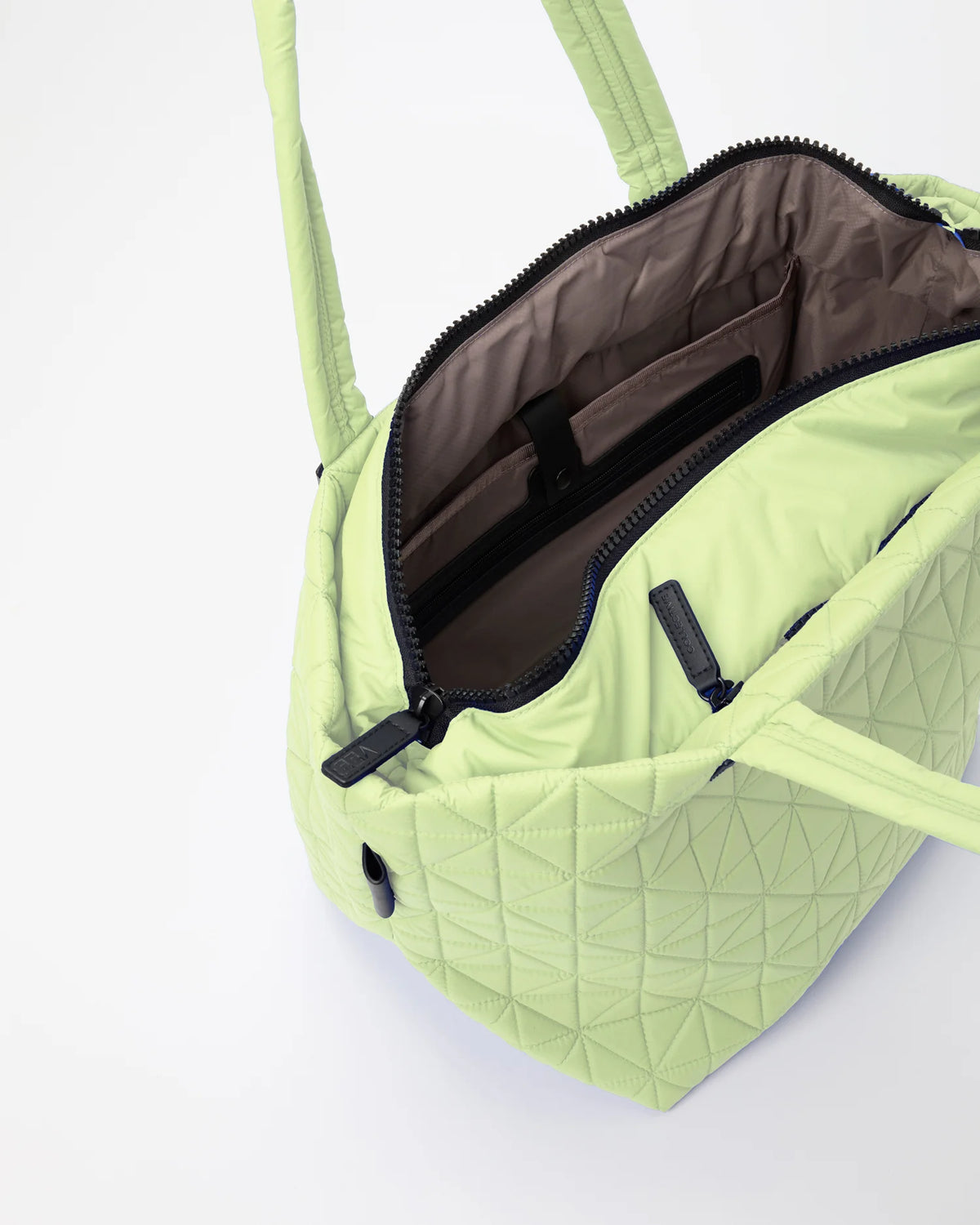Open Vee Collective Vee Tote Medium in Limelight, showing the quilted exterior, top zipper, and interior compartments of the tote bag.