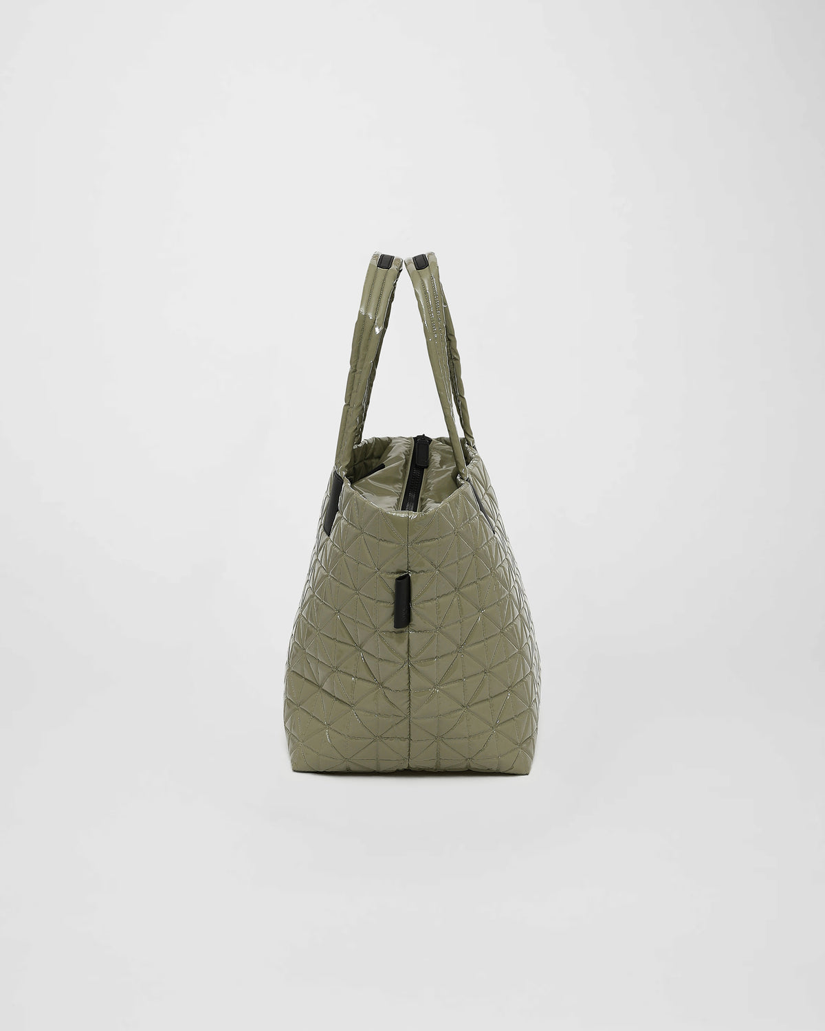 A medium sage vinyl tote bag with a quilted triangle design and geometric stitching is shown from the side. The bag features two sturdy handles and a top zipper, making it a stylish and functional accessory for various occasions.