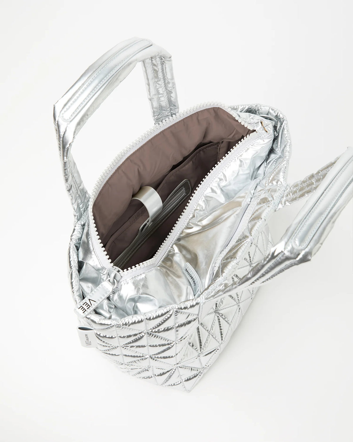 Silver quilted handbag with brown interior lining on a white background
