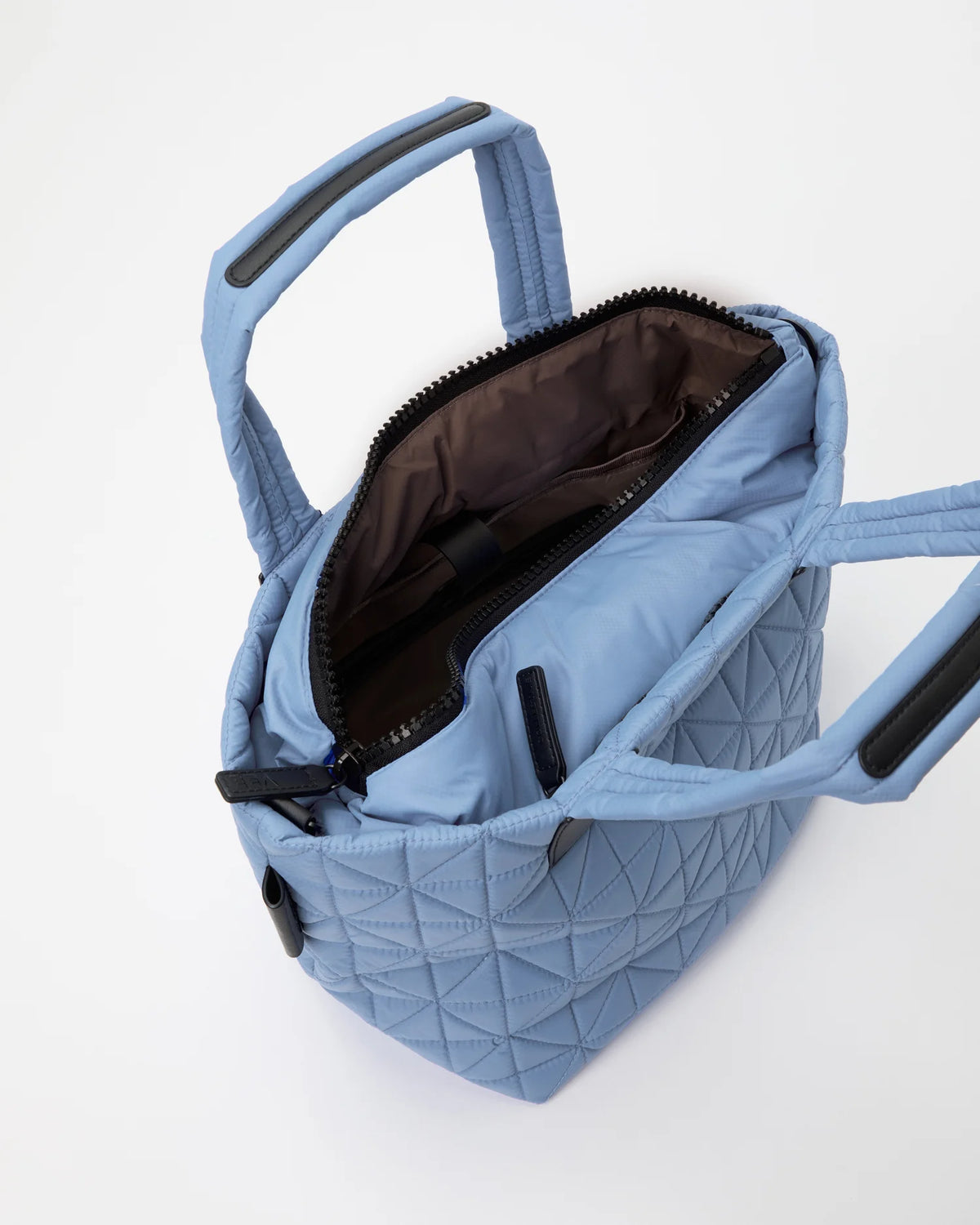 Open Vee Collective Vee Tote Small in Pigeon Blue, showing the quilted exterior, top zipper, and interior compartments of the tote bag.